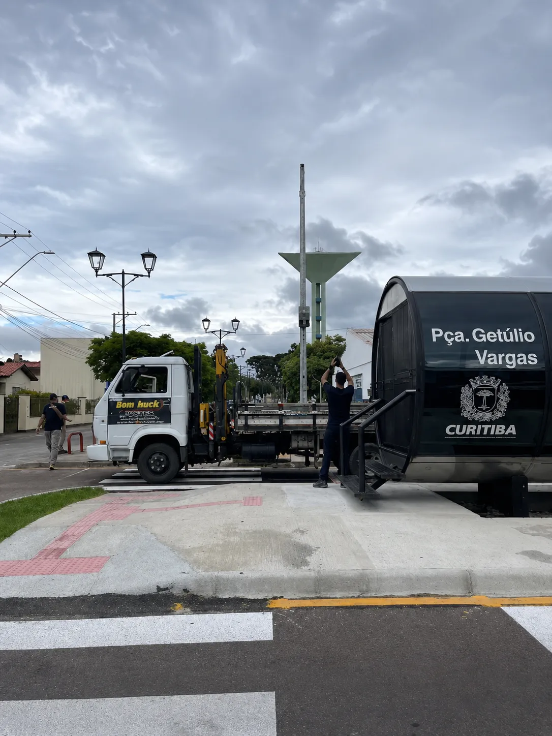 Caminhão da Bom Huck com guindaste em obra numa praça de Curitiba